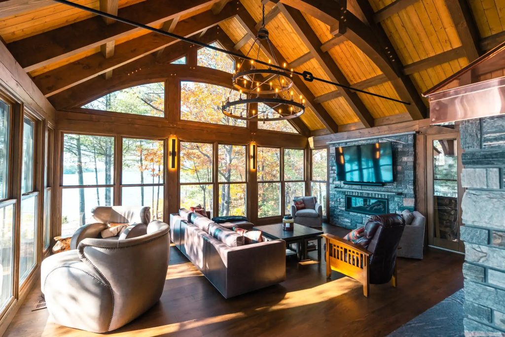 Living room with large water-facing windows, a brick fireplace and comfortable furniture