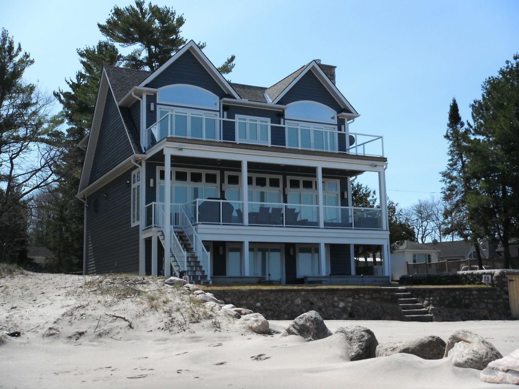 Three-storey custom cottage with Cape Cod exterior on the beach